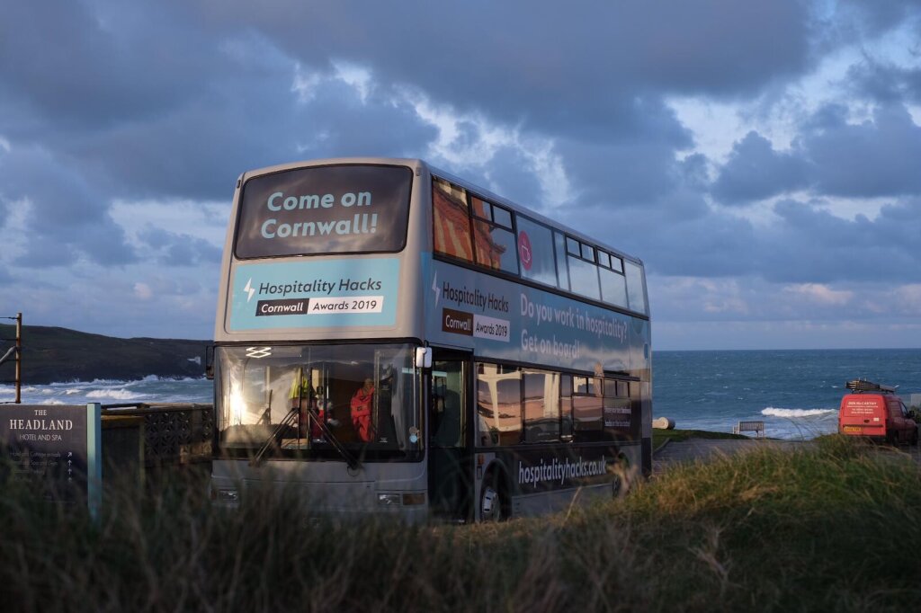 A double decker bus parked near the sea.